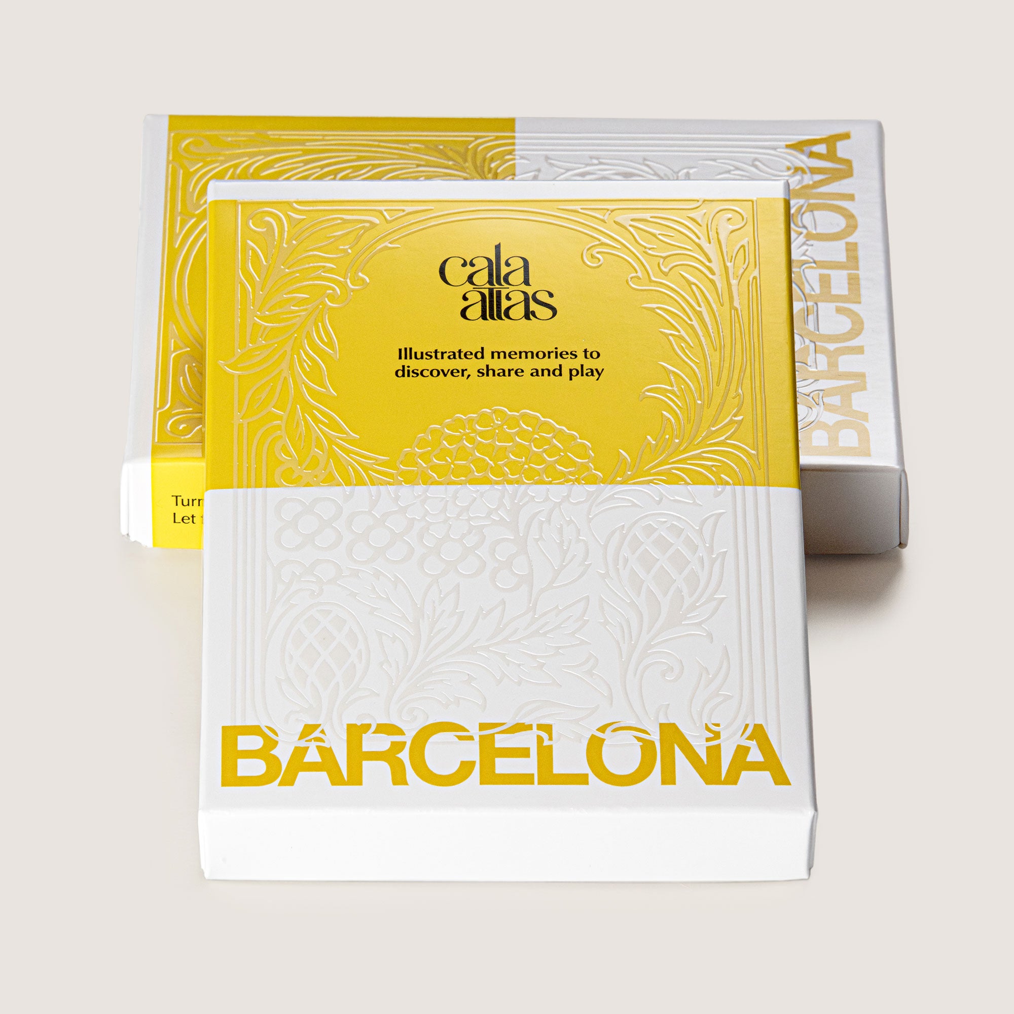 Two Cala Atlas Barcelona Story Deck boxes with embossed details on a yellow and white cover
