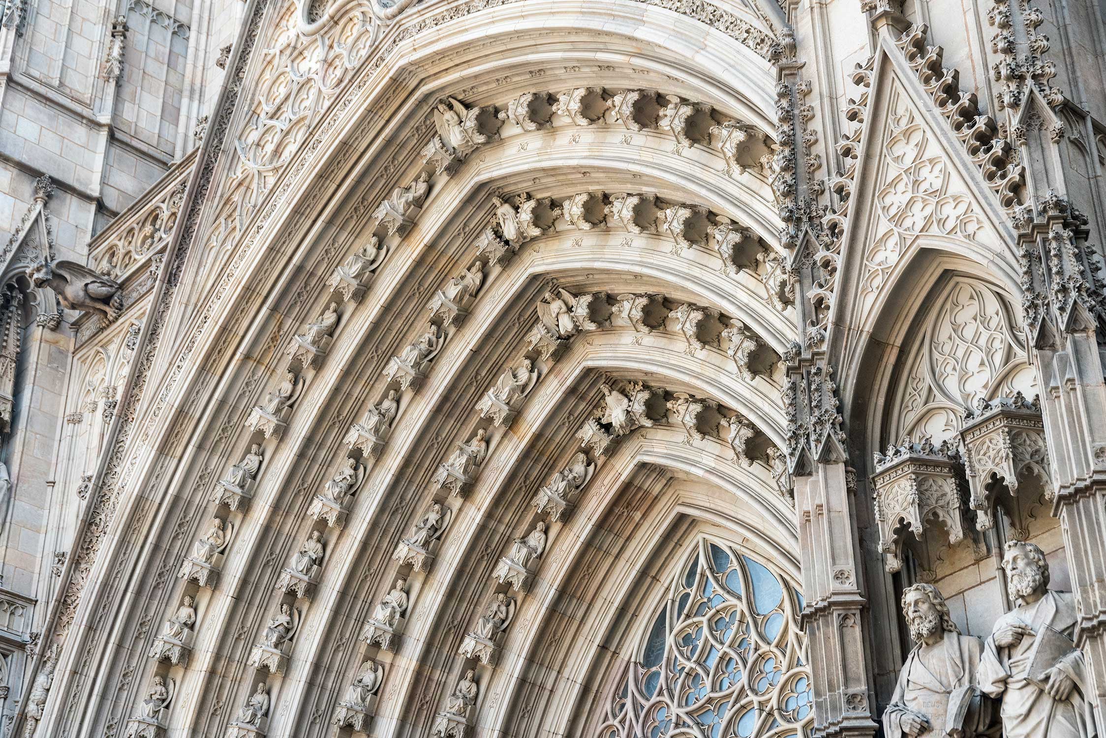 Detailed view of a Gothic arch filled with rows of carved stone figures and decorative patterns